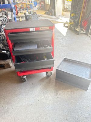 une photo d'un garage avec un chariot à outils et des outils