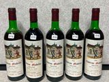 quatre bouteilles de vin sont alignées sur un plan de travail