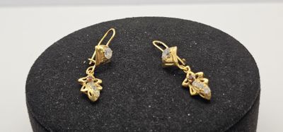 une paire de boucles d'oreilles dorées dans un coffret noir