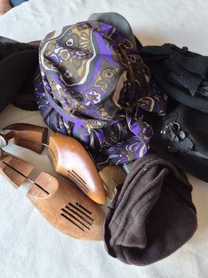 un tas de chaussures et une écharpe posés sur un lit