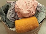 a bucket full of clothes sitting on a table