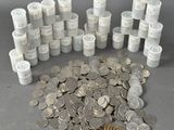 une pile de pièces et un rouleau de papier toilette posés sur une table