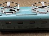 a small blue train car with two windows on the side of it