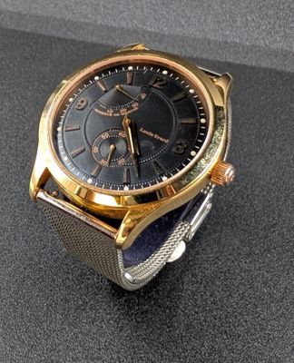 a gold and black watch on a black surface