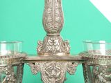 a silver chandelier with three glasses on top of it