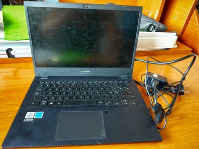 un ordinateur portable posé sur un bureau avec un chargeur