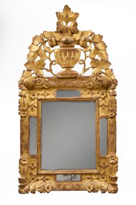une image représentant un miroir à cadre doré orné de fleurs et de feuilles