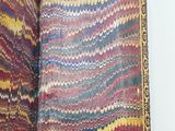 someone is holding a book with a colorful pattern on it