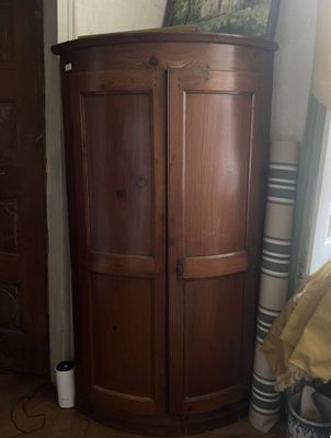 un grand meuble en bois dans le coin d'une pièce
