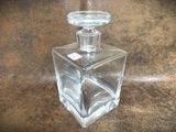 a clear glass bottle with a glass stopper on top of it
