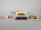 trois trains miniatures assis l'un à côté de l'autre sur une table
