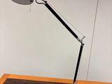 une photo d'une lampe de bureau noire posée sur une table en bois
