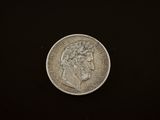 a close up of a silver coin on a black surface