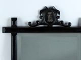 a mirror with a black frame on a white wall