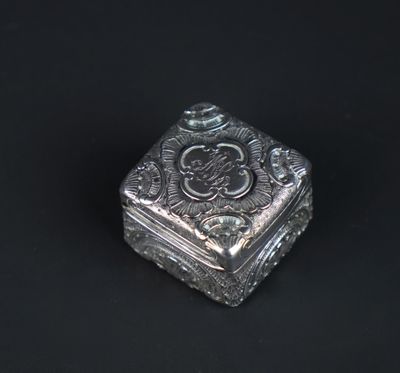 a small silver box with a design on the lid