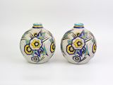 une paire de vases en céramique ornés de motifs colorés sur fond blanc