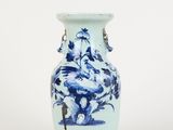 un vase bleu et blanc posé sur une surface blanche