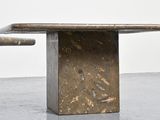 a concrete table with a marble top on a concrete floor