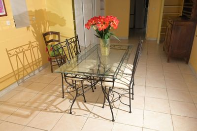 une table en verre sur laquelle se trouve un vase de fleurs
