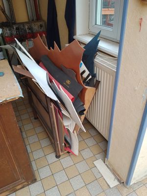 une pièce où le sol est encombré d'objets et qui possède une fenêtre