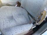 a dirty seat in the back of a car with a broken arm rest