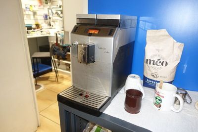 une machine à café posée sur une table, à côté d'un paquet de café