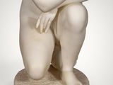an image of a statue of a woman kneeling on a marble base