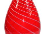 a red vase that is sitting on a white surface