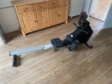 a rowing machine that is on the floor in a room