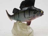 figurine of a fish on a rock on a white surface