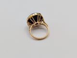 a gold ring with a black stone in the center