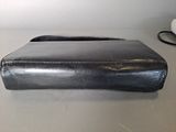 leather laptop case on a table next to a mouse and keyboard