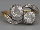 une photo représentant une paire de bagues en diamant posées sur une table