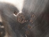 a close up of a silver vase with a flower on it