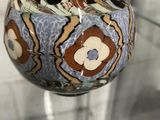 un vase en verre orné d'un motif bleu et marron