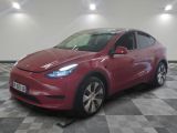 Le SUV Tesla rouge est garé dans le garage, sur un sol à damier.