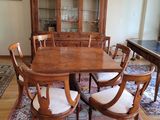 une table de salle à manger avec des chaises et un lustre en arrière-plan