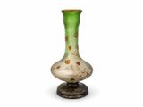 a green and white vase sitting on top of a metal stand