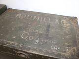 an old metal box with writing on it sitting on a table