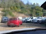 many cars parked in a parking lot with a mountain in the background