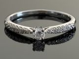 a close up of a diamond ring on a black surface