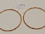 une paire de boucles d'oreilles en or sur fond blanc