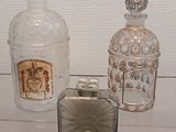trois bouteilles en verre et un briquet posés sur une table