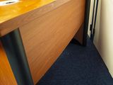 un homme debout devant un bureau sur lequel se trouve un ordinateur portable