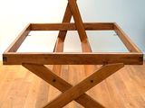 a wooden table with a glass top sitting on a hard wood floor