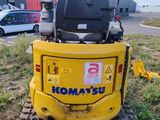 the back end of a small yellow construction vehicle parked in a field