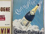 several books are sitting on a table with a bottle of wine in front of them