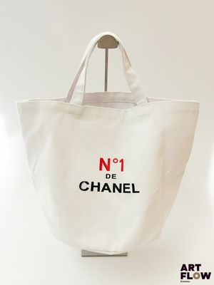 un sac cabas Chanel orné du numéro 1, accroché à un mur