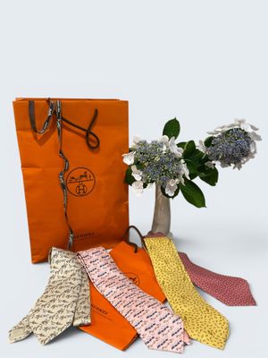 five different ties and a vase of flowers on the table