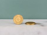 une pièce d'or posée à côté d'une petite pièce d'or